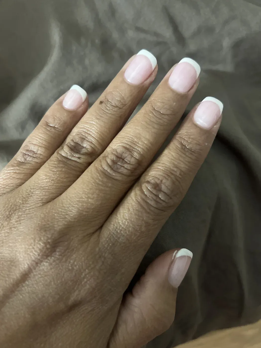 Soft pink French manicure on a client's hand at Nails Trend